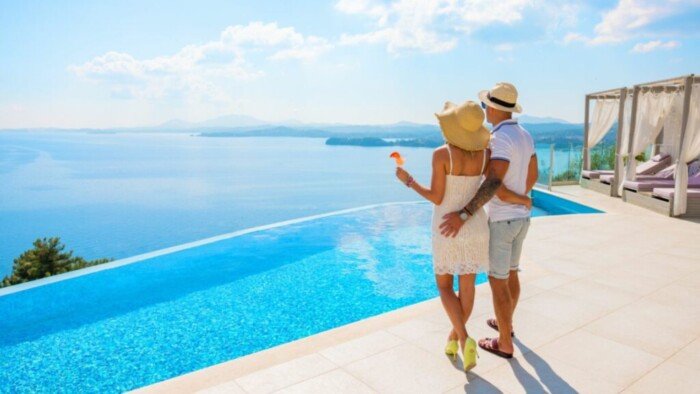 A Man and a Woman Wearing Sun Hats Looking a Swimming Pool